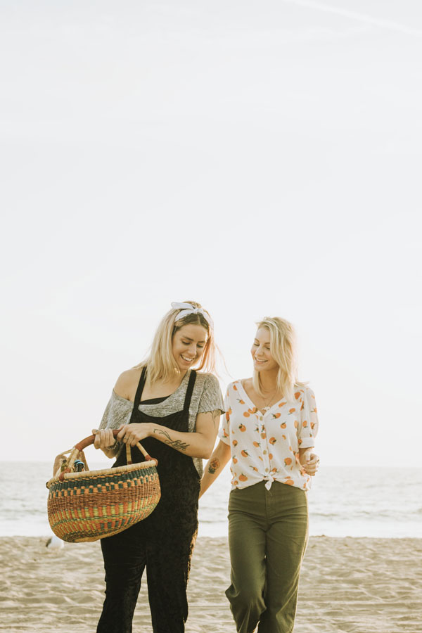 friends-walking-beach-with-picnic-basket